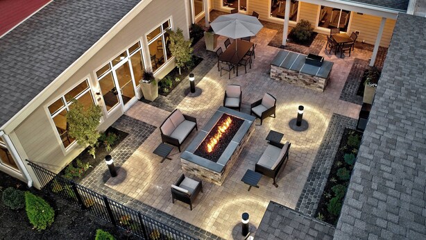 Eine Terrasse im Freien mit Feuerstelle, Sitzgelegenheiten und Essbereich.