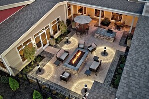 Eine Terrasse im Freien mit Feuerstelle, Sitzgelegenheiten und Essbereich.