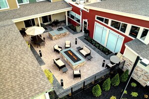 An outdoor patio with a fire pit, seating, and a covered area with a table and chairs. - Residence Inn by Marriott Harrisburg North (Harrisburg)