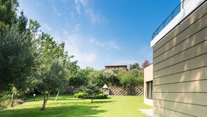 Ein modernes Haus mit gepflegtem Rasen und einer Steinmauer im Hintergrund.