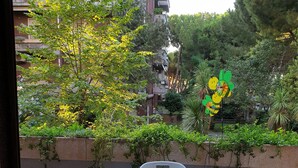 An outdoor patio with a table and chairs, surrounded by greenery and a view of a building. - Nice apartment in Silvi Marina "The Pearl of the Adriatic" (Silvi)