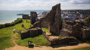 The ruins of a historical building with a view of the sea and a modern city in the background. - Apollo Guest House (Hastings)