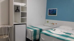 Un dormitorio con dos camas, un armario y un escritorio.