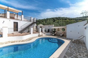 A swimming pool with a stone border, a staircase leading to a terrace, and a view of a hilly landscape. - Romantic holiday home among the olive groves (Villanueva de Algaidas)
