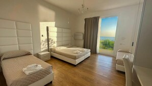 Un dormitorio moderno con dos camas, un escritorio y vistas al exterior.