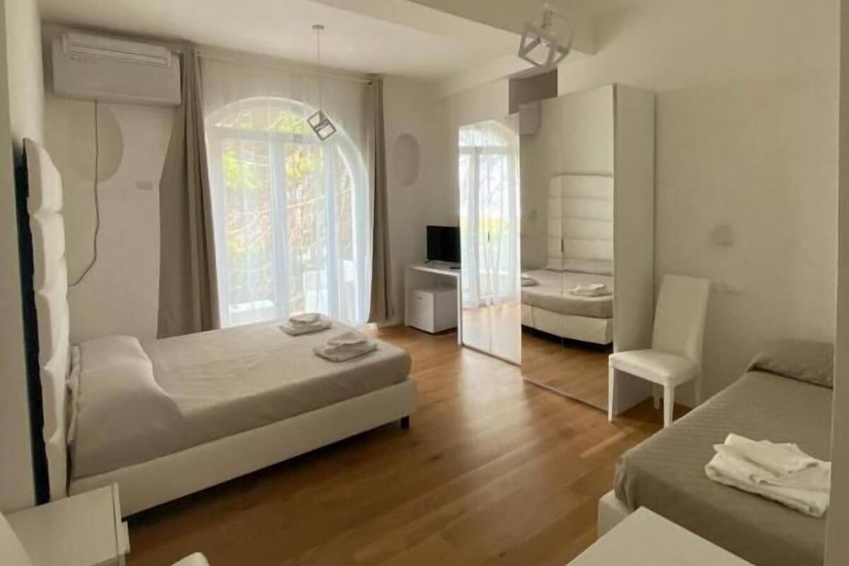 Una habitación de hotel moderna con una cama, un escritorio, una silla y un televisor.