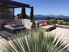 Terraço no telhado com cama, área de estar e plantas em vasos.