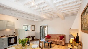 Un coin repas avec une table dressée pour quatre personnes, un canapé et un fauteuil en osier.