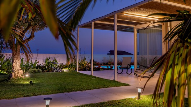 A modern outdoor patio area with a pool, seating, and a covered structure. - At the home of Giò, villa with pool (Marina di Ragusa)