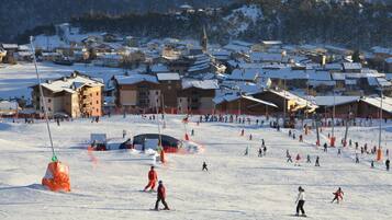 Een wintersportgebied met meerdere gebouwen, waaronder chalets en een gebied voor de skilift.