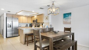 Una cocina moderna con armarios de madera, electrodomésticos de acero inoxidable y una isla central con asientos.