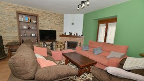 Una sala de estar con un conjunto de sofás, una mesa de centro, una chimenea y una estantería.
