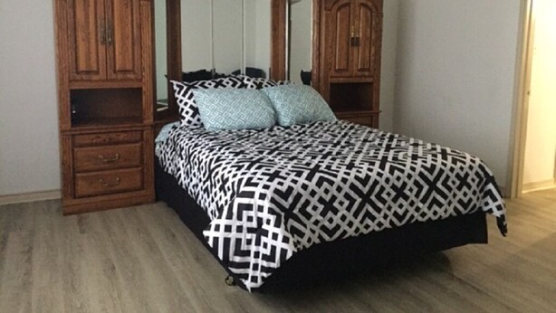 A bedroom with a bed, wooden wardrobe, and a ceiling fan. - Rural Relaxation in Reklaw! (Reklaw)