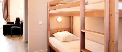 A bunk bed with a round light fixture above the middle bunk.