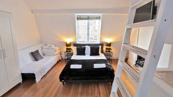 Une chambre à coucher avec un lit, une table de chevet, une armoire et une fenêtre.