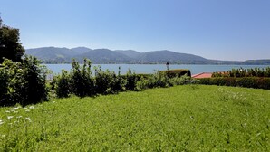 Un camp verdós amb un llac i muntanyes al fons.