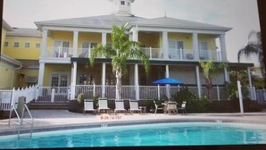 A two-story building with a pool in front.