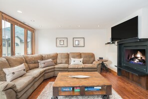 Relax in this stylish living room with a cozy fireplace, flat-screen TV, and comfortable seating area.