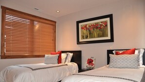 A hotel room with two beds, a large window with blinds, a framed artwork on the wall, and a decorative item on the nightstand. - Telluride Lodge Condo #538 (Telluride)