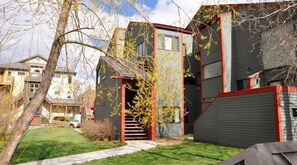 Une maison moderne à deux étages, dotée d’un jardin visible à l’avant et d  ’un escalier menant à l’entrée.
