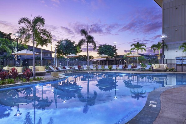A pool area with lounge chairs and umbrellas, surrounded by palm trees and a building. - Residence Inn by Marriott Oahu Kapolei (Kapolei)