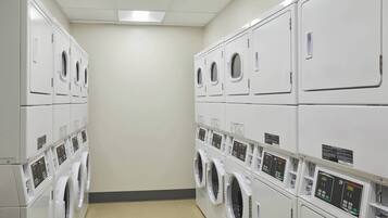 A laundry facility with multiple rows of stacked washing machines.
