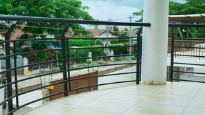 A balcony with a view of a garden and buildings. - Beautiful Secure Home With 24 hour Security (Accra)