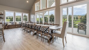 A spacious dining area with high ceilings and large windows offering a view of the countryside. - Foxridge (Sleeps 34) by Bear Lake Luxury Rentals (Garden City)