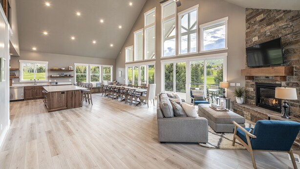 A spacious living area with a fireplace, large windows, and a dining area. - Foxridge (Sleeps 34) by Bear Lake Luxury Rentals (Garden City)