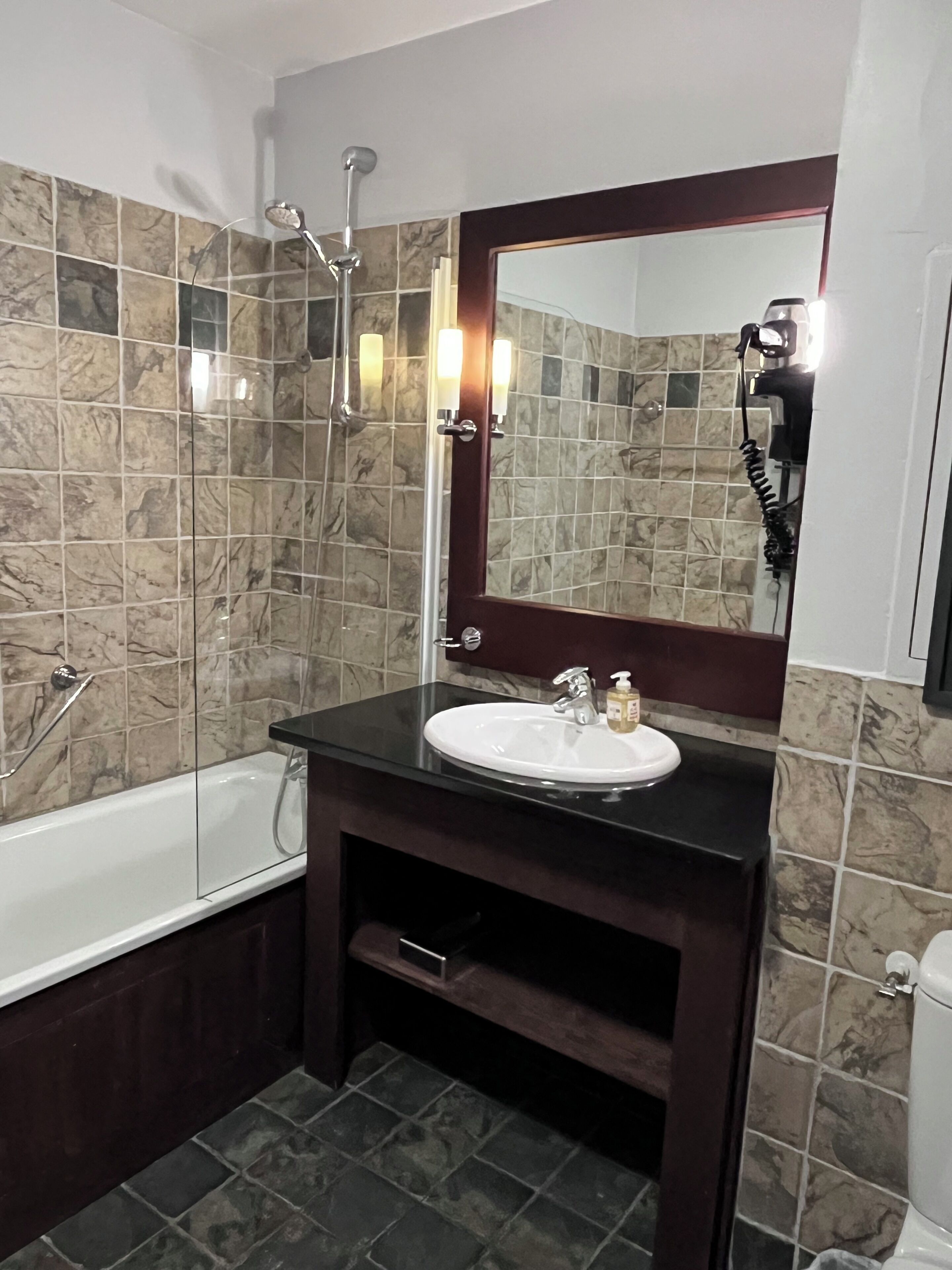 A bathroom with a bathtub, a sink, and a shower.