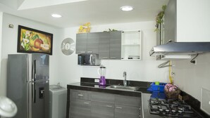 A modern kitchen with a refrigerator, microwave, stove, sink, and cabinets. - EDIFICIO POSIEDON located in the exclusive area of Laugito (Cartagena)