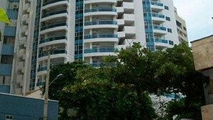 A tall, modern building with multiple balconies and a curved facade. - EDIFICIO POSIEDON located in the exclusive area of Laugito (Cartagena)