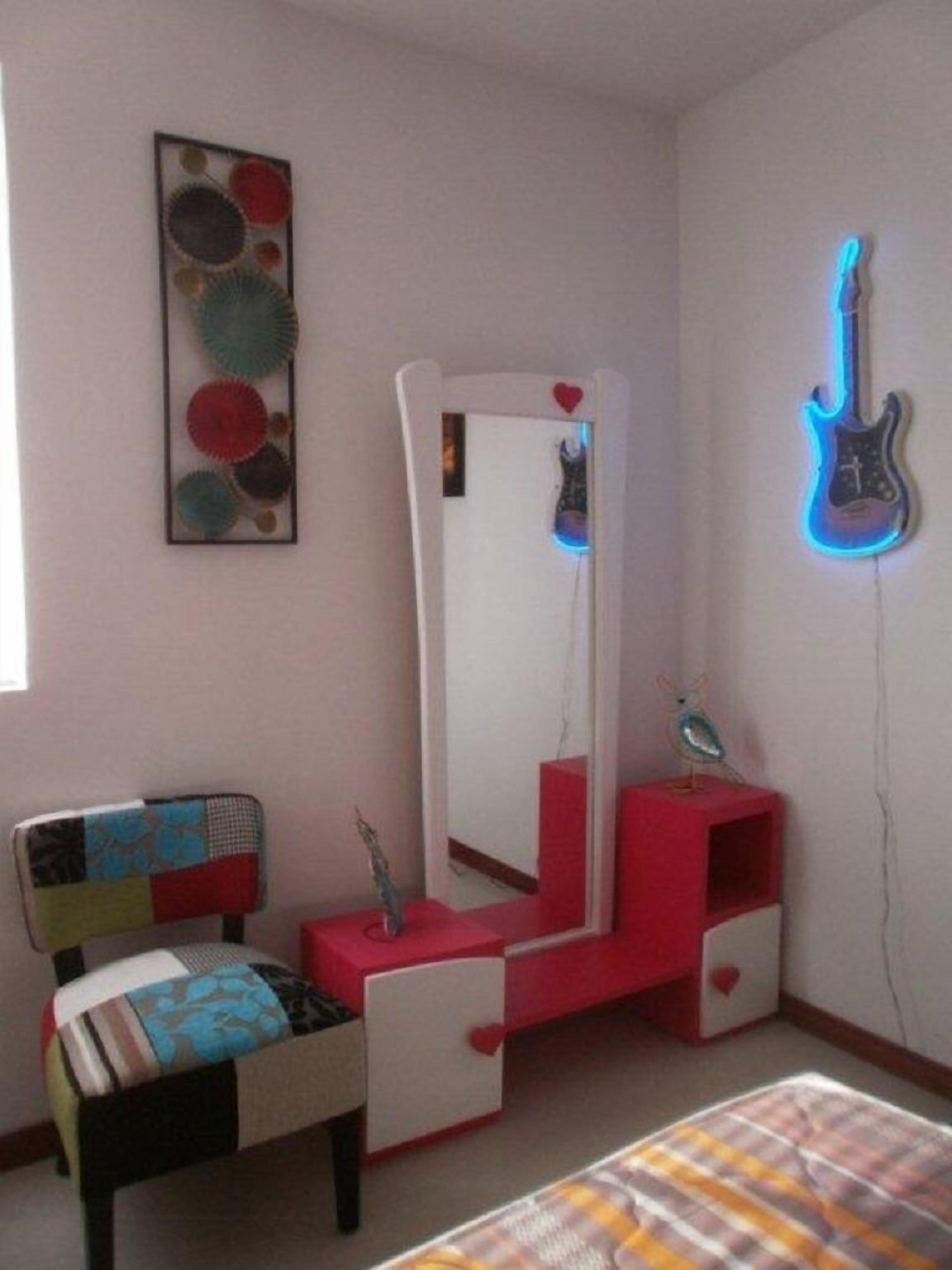 A bedroom with a bed, a dresser, a mirror, and a guitar-shaped light fixture.