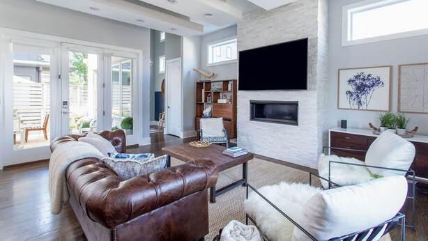 A spacious living room with a leather sofa, a coffee table, and a fireplace.