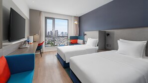 A hotel room with two beds, a TV, a desk with a lamp, a chair, and a view of a cityscape. - Holiday Inn Express Kunming West by IHG (Kunming)
