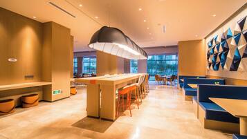 Un comedor moderno con una barra central, disposición de asientos y un diseño geométrico en la pared.