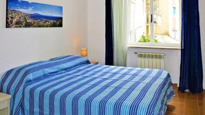 A bedroom with a bed, a window, a radiator, and a painting on the wall. - Ritamar by Interhome (Sorrento)