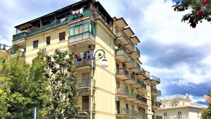 A multi-story residential building with balconies, a clock on the facade, and laundry hanging on the balconies. - Ritamar by Interhome (Sorrento)
