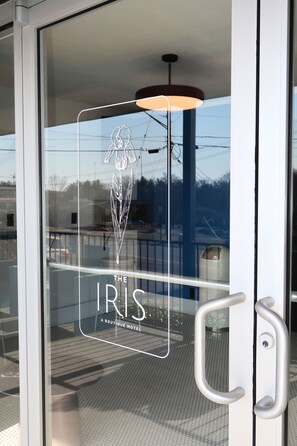 A glass door with a logo and text indicating 'The Iris Boutique Hotel'. - The Iris Motel (Nashville)