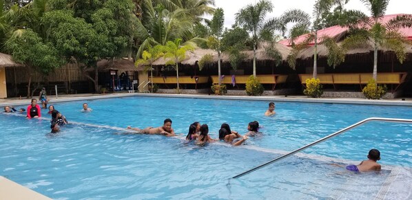 Una piscina al aire libre, cabañas de piscina (de pago), tumbonas