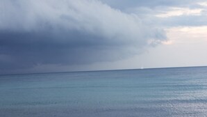 Blick auf das Meer mit einem entfernten Segelboot.