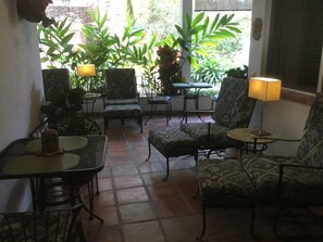 A cozy patio area with patterned furniture, a table, and chairs.