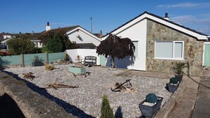A residential property with a stone facade, a white exterior, and a gravel driveway. - Penmon View, Moelfre, Anglesey. With sea and mountain views. (Moelfre)