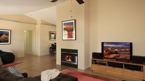 Ein Wohnzimmer mit Kamin, Fernseher und einer Couch.