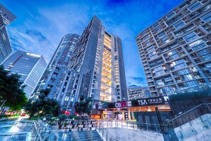A high-rise building with multiple floors, a prominent entrance with signage, and a staircase leading to the entrance. - Shenzhen T Hotel Apartment (Shenzhen)