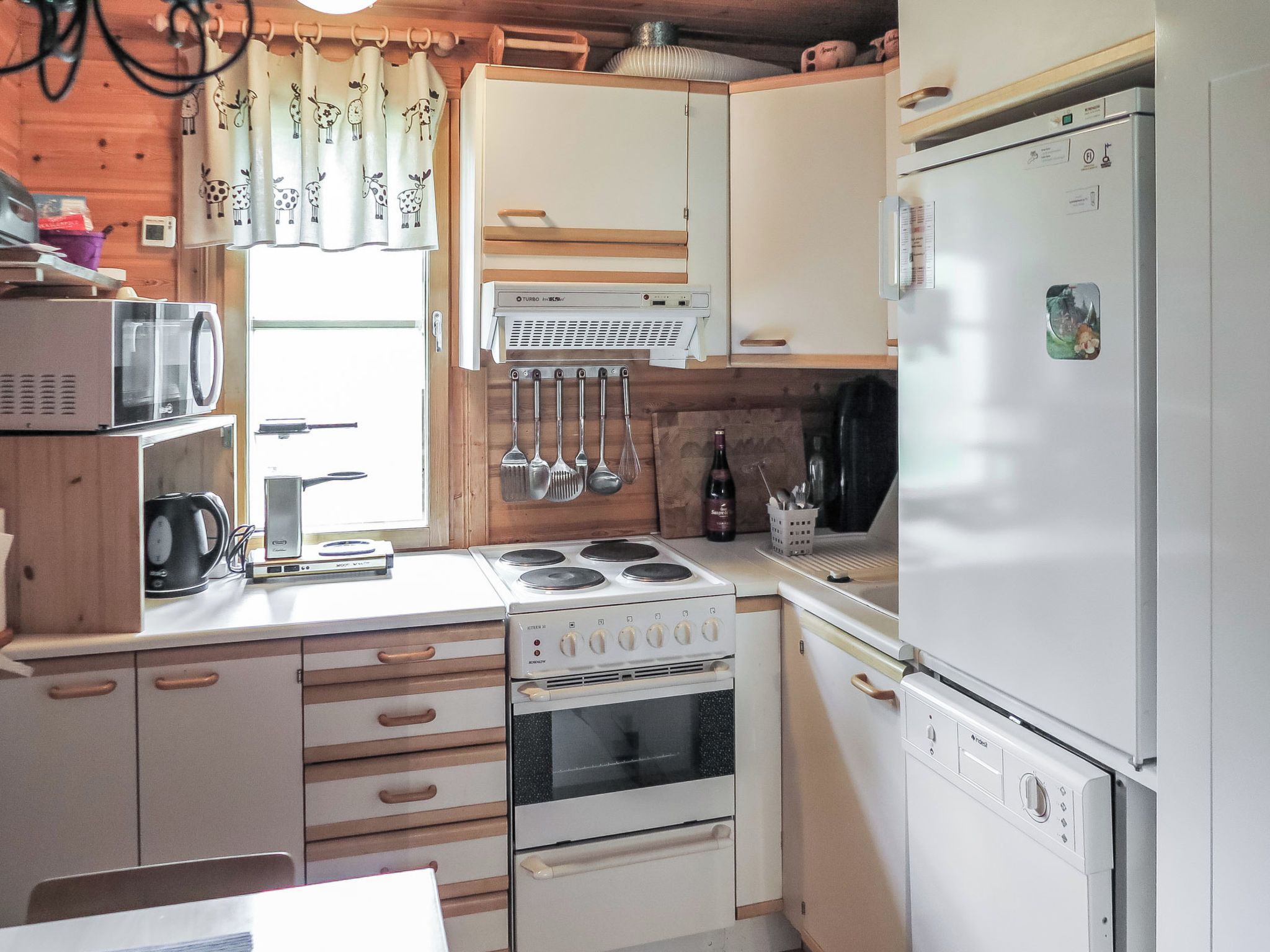 A compact kitchen with a stove, oven, microwave, and refrigerator.