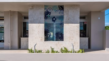 A building facade with a large vertical banner displaying 'Sunset Resort Canphou' and a floral design.