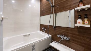 A modern bathroom with a bathtub, a shower, a sink, and a mirror. There are two shelves with toiletries.