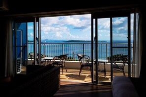 Un balcón con vistas al mar, una mesa y dos sillas.