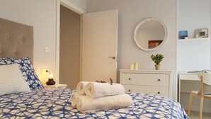 A bedroom with a bed, a desk, a chair, a dresser, and a mirror. - San Lorenzo beach front center apartment (Gijón)